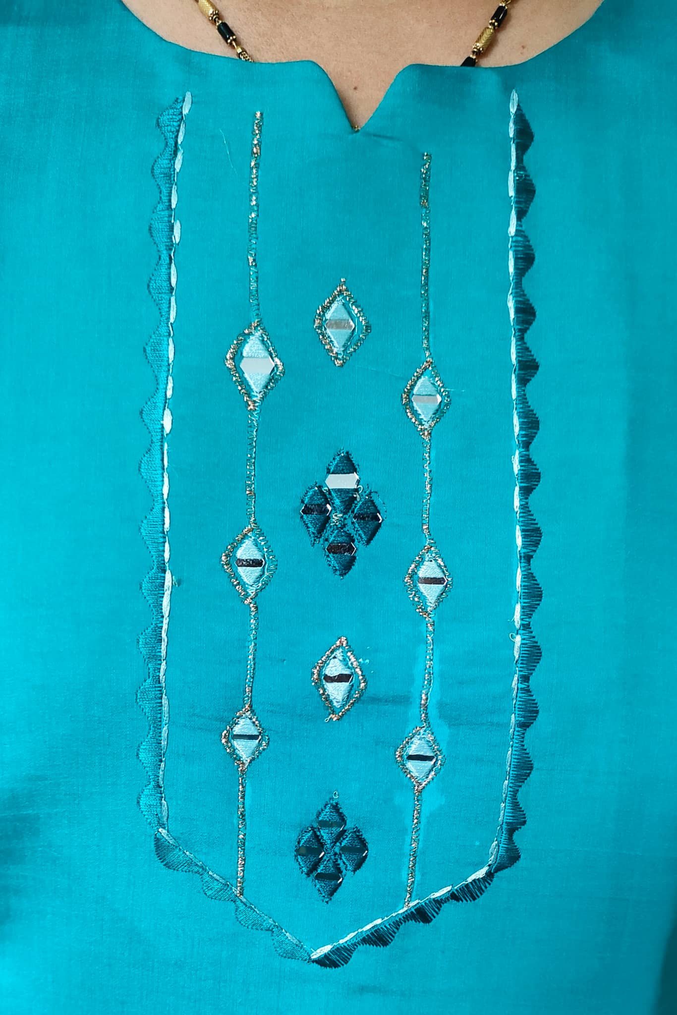 Close-up of Elegant Collections premium cotton silk kurti featuring intricate embroidered design in turquoise