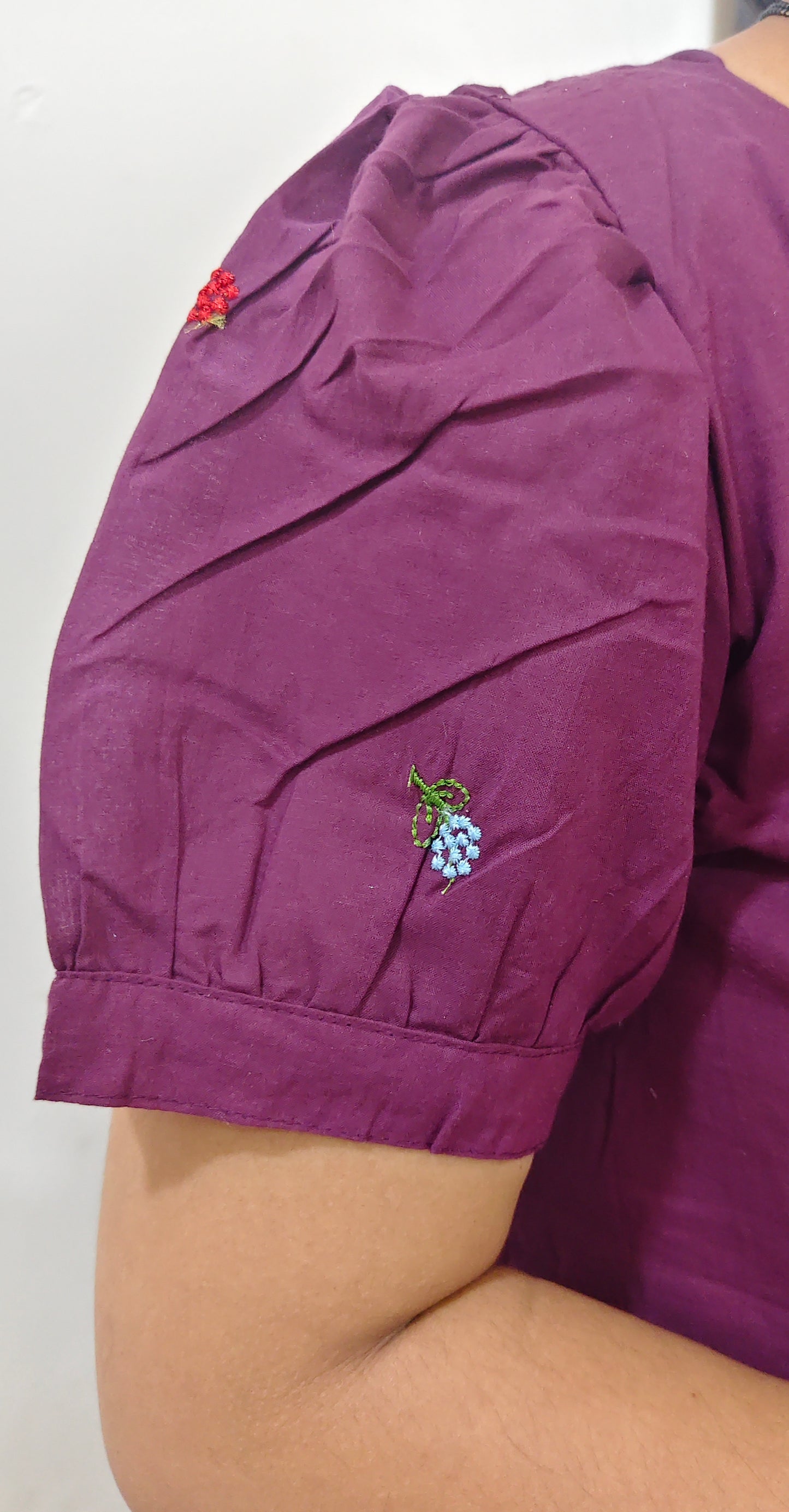 Detail of a purple cotton dress maxi showcasing embroidered floral accents on the sleeves