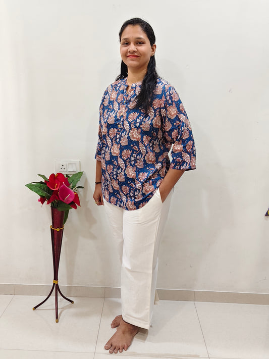 Elegant women wearing a floral cotton short kurti for women with white pants and a stylish design
