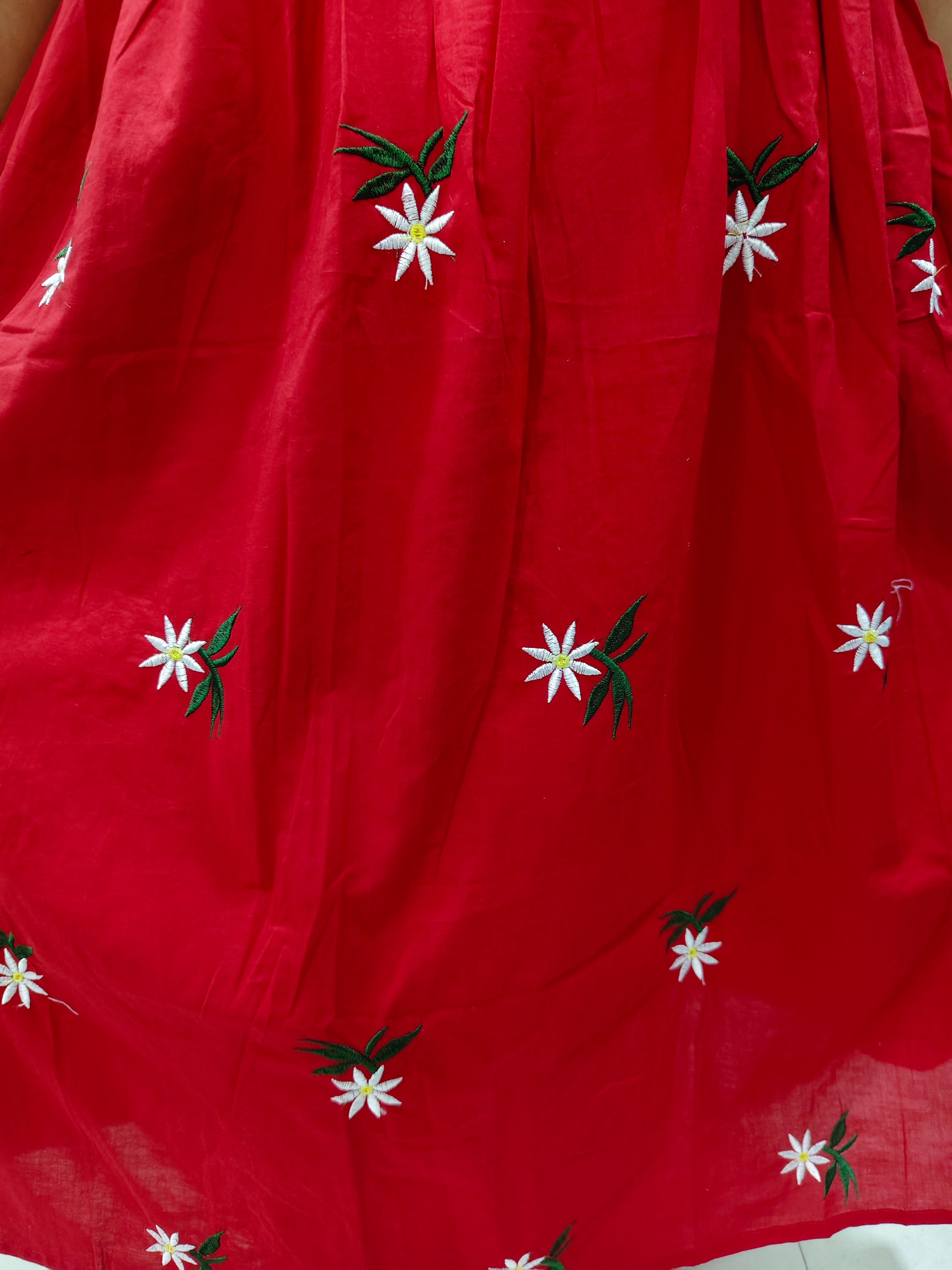 Vibrant red dress embroidered with white floral patterns and green leaves for a stylish look