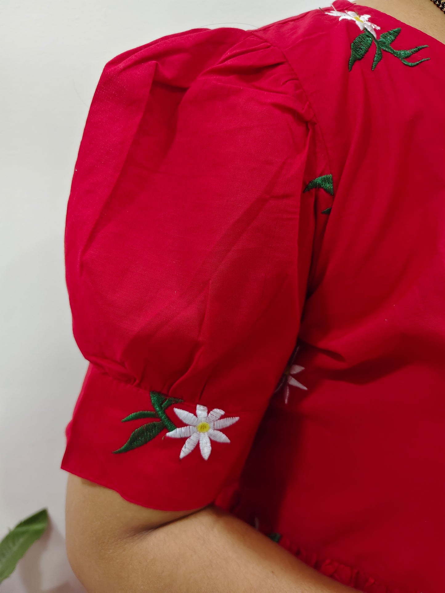 Elegant red dress embroidered with floral details on the sleeve for a stylish look