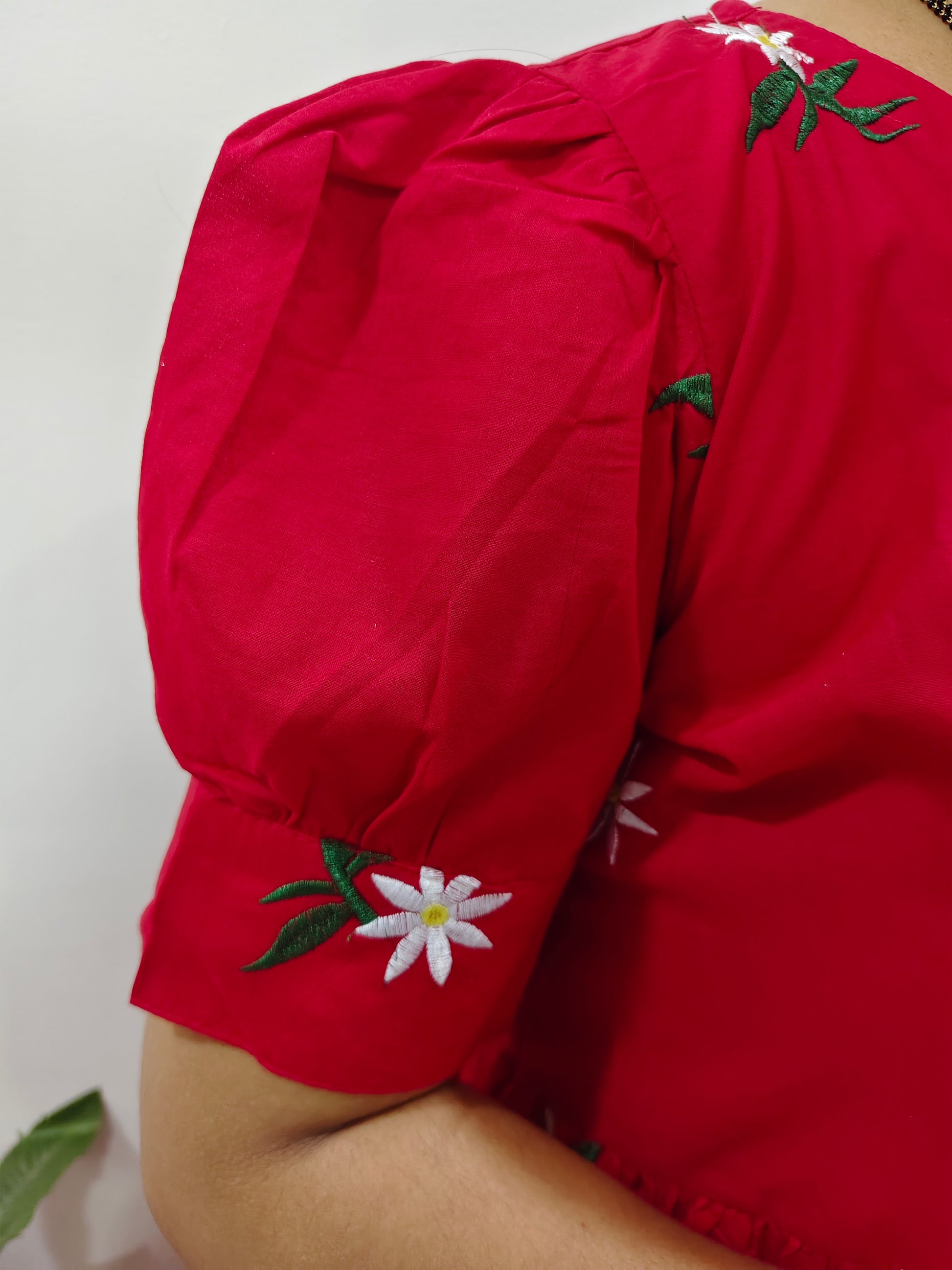 Elegant red dress embroidered with floral details on the sleeve for a stylish look