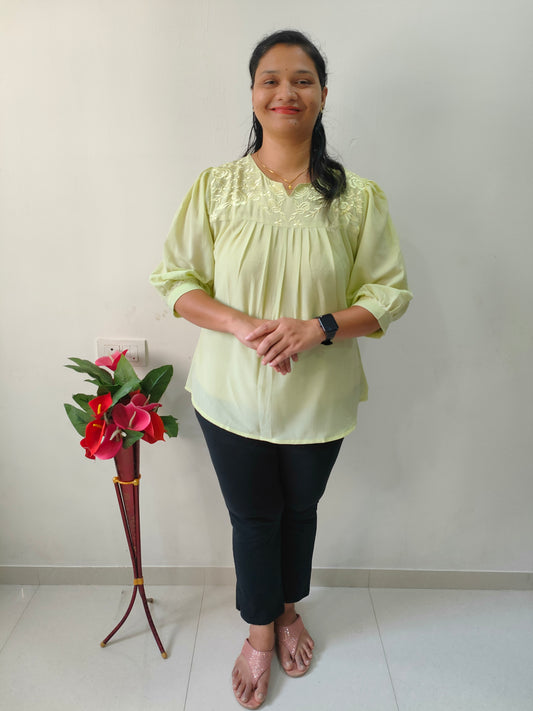 Elegant lemon yellow short kurti with embroidery design, styled with black pants for a chic look