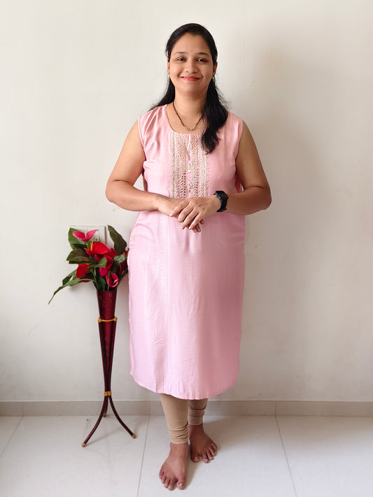 Woman wearing pink mirror work kurti for women with sleeveless design and beige leggings