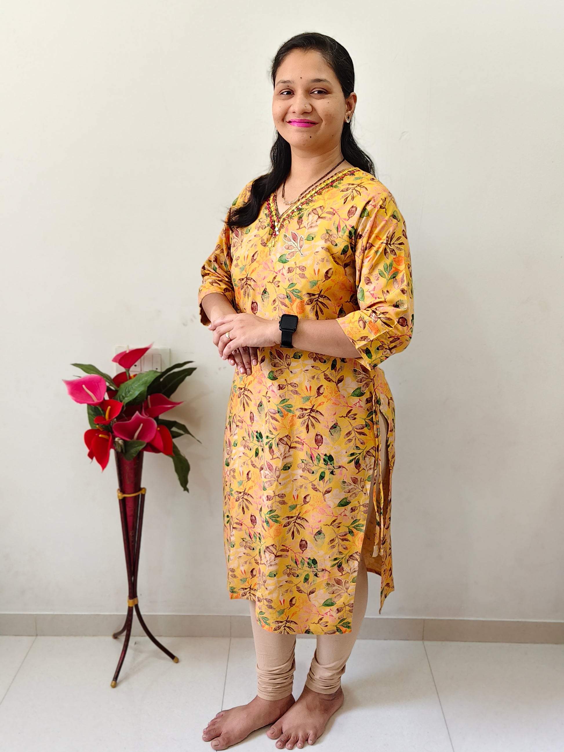 Elegant Collections mustard yellow mirror work kurti with floral patterns, styled for casual wear