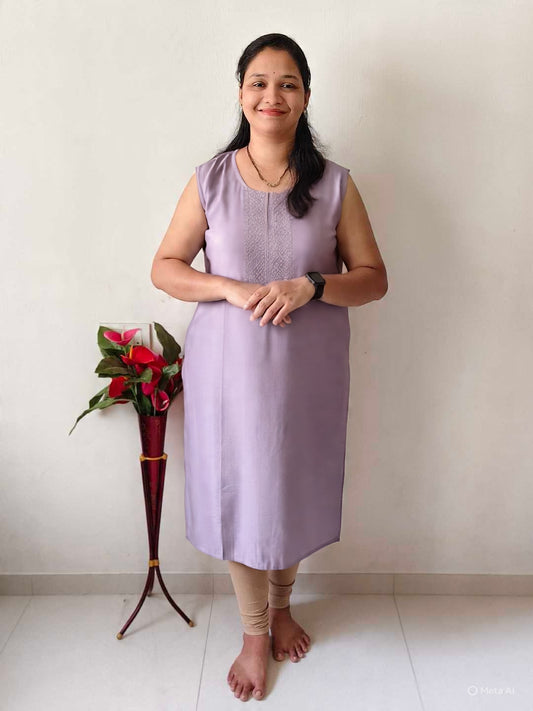 Woman wearing a premium viscose mirror work kurti in lavender sleeveless design standing indoors